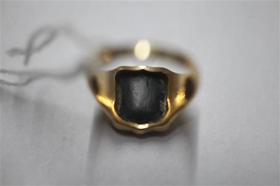 An early 20th century 18ct gold and bloodstone set signet ring, the matrix carved with crest and motto, size R.